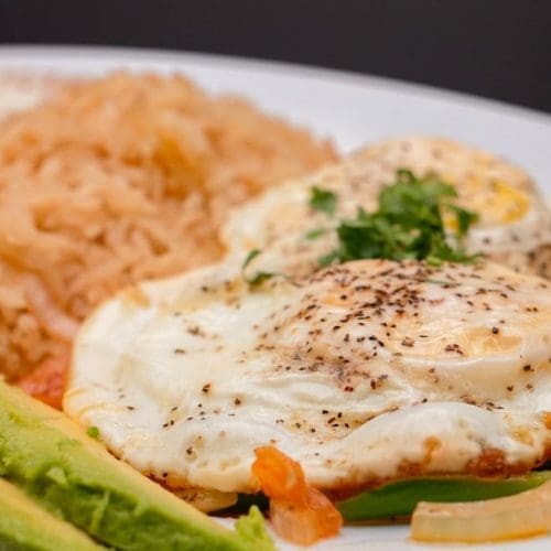 Sunny-side-up eggs served with white rice and beans in Kennewick, WA.